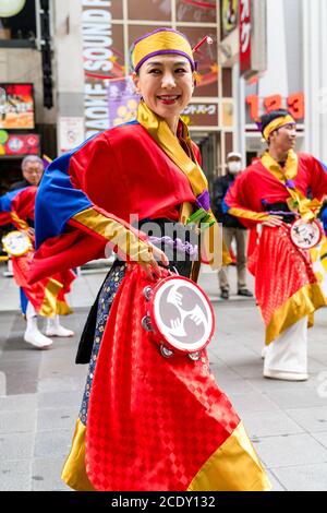 Gros plan d'une femme japonaise mûre, faisant partie d'une équipe de danse de yosakoi, dansant avec le tambourin pendant le festival Kyusyu Gassai à Kumamoto au Japon. Banque D'Images