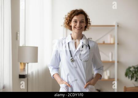 Portrait jeune femme souriante portant un uniforme, médecin debout au bureau Banque D'Images