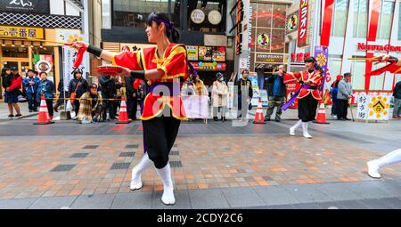 Gros plan de l'équipe de danse japonaise yosakoi, dansant avec des tambourines dans une salle de shopping pendant le festival Kyusyu Gassai à Kumamoto au Japon. Banque D'Images