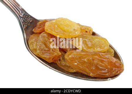 Dans la vieille cuillère dorée il y a un petit tas de nourriture - rasines d'ambre sèches fruits baies isolées macro Banque D'Images