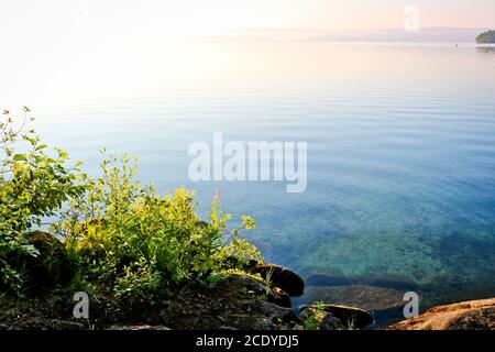 Aube sur la surface de l'eau du lac. Eau calme et claire. Turgoyak, Russie. Banque D'Images