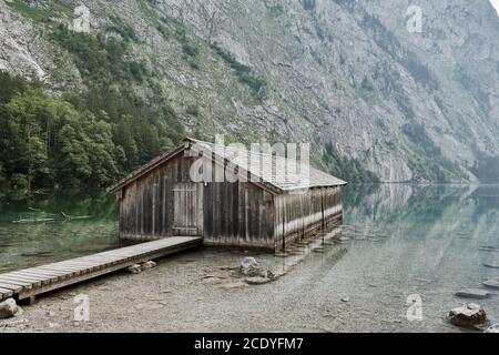 Hangar à bateaux en bois avec jetée sur le magnifique lac Obersee dans le paysage alpin à Schoenau am Koenigssee, Allemagne. Banque D'Images