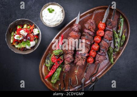 Brochette barbecue traditionnelle grecque souvlaki avec salade de fermier et tzatziki comme vue de dessus sur une ancienne plaque rustique Banque D'Images