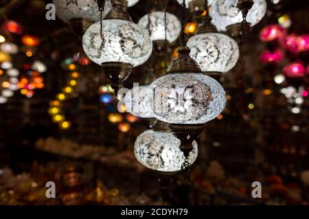 Des lampes en verre blanc sont accroché dans une boutique de souvenirs Banque D'Images