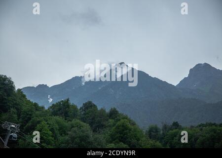 Paysage de montagne avec nuages et forêt verte. Vapeur s'élevant des montagnes. Paysage d'été Banque D'Images