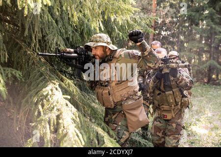 Le chef militaire examine la portée du fusil et prépare son équipe pour l'attaque Banque D'Images