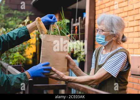 livraison d'épicerie à une femme âgée pendant une pandémie Banque D'Images