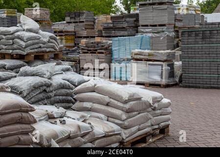 Stockage de différents types de matériaux de pierre de construction comme les carreaux de sol, les palettes et le ciment Banque D'Images