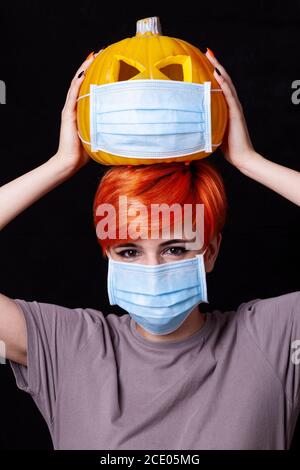 fille avec citrouille avec masque facial - halloween dans le âge du coronavirus Banque D'Images