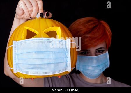 fille avec citrouille avec masque facial - halloween dans le âge du coronavirus Banque D'Images