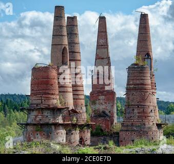 Vieux tuyaux de briques cassés de fours dans une usine de marbre abandonnée à Ruskeala, Karelia, Russie Banque D'Images