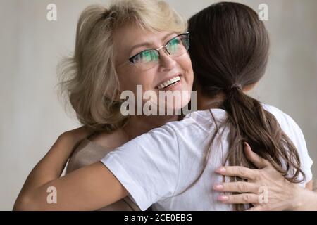 Reconnaissant sincère bonne maman des années 60 câliner affectueux fille adulte. Banque D'Images