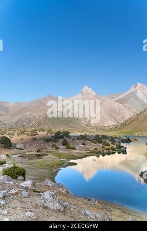 La vue sur le domaine de Pamir et le camping paisible sur le lac Kulikalon dans les montagnes de Fann au Tadjikistan. Reflet coloré en pur Banque D'Images