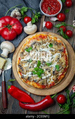 Pizza maison avec tomates, champignons et basilic vert. Banque D'Images