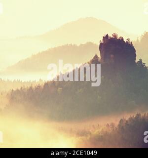 Paysage brumeux avec brouillard entre les collines et le ciel orange à l'intérieur lever du soleil Banque D'Images