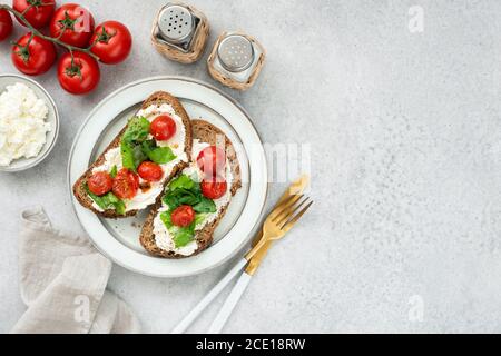 Bruschetta italienne saine avec ricotta, laitue romaine et tomates cerises grillées. Vue de dessus de table, espace de copie Banque D'Images