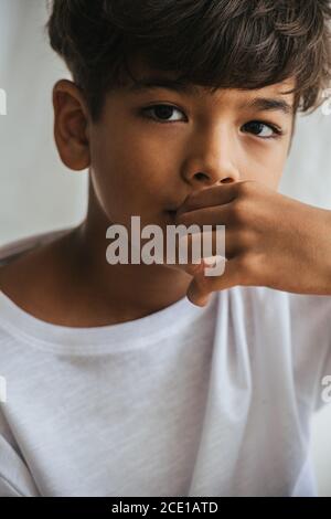 Portrait d'un enfant asiatique indien touchant sa bouche avec la main. Gros plan. Banque D'Images