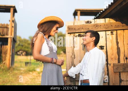 Un couple regardant et souriant les uns les autres à la porte d'un chariot en bois. Ranch concept Photographie Banque D'Images