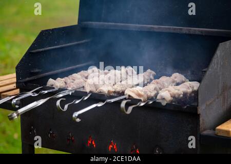 Vue rapprochée de délicieux grillades de porc brut sur le barbecue. Brocher la viande cuire au feu et à la fumée. Personne Banque D'Images
