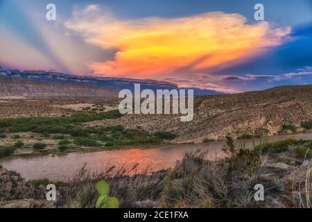 Coucher du soleil se reflétant dans le fleuve Rio Grande à Boquillas Canyon avec en toile de fond la montagne de Sierra del Carmen au Mexique. Banque D'Images