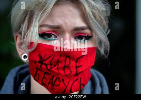 Moscou, Russie. 30 août 2020 UNE femme portant un masque facial se tient dans une "chaîne de solidarité" de protestation biélorusse lors d'un rassemblement devant l'ambassade du Bélarus pour soutenir les Biélorusses protestant contre les résultats officiels de l'élection présidentielle biélorusse de 2020, à Moscou, en Russie. L'inscription dans le masque indique « long Live Belarus » Banque D'Images