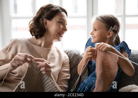 Famille multigénérationnelle heureuse impliquée dans la création de vêtements chauds. Banque D'Images