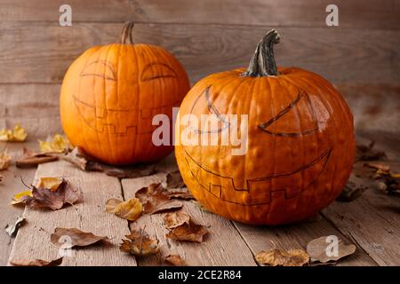 Citrouilles aux visages effrayants dessinés sur des planches en bois. Fabrication de lanternes de type Jack-o-lanternes pour Halloween. Banque D'Images