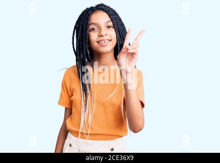 Mignon afro-américaine fille portant des vêtements décontractés montrant et pointant vers le haut avec les doigts numéro deux tout en souriant confiant et heureux. Banque D'Images
