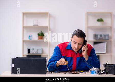 Jeune homme réparateur réparant un ordinateur PC Banque D'Images