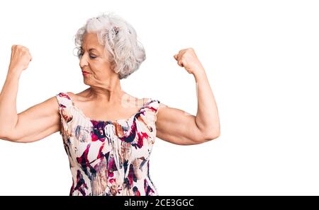 Femme sénior aux cheveux gris vêtue de vêtements décontractés montrant les bras muscles souriant fier. Concept de forme physique. Banque D'Images