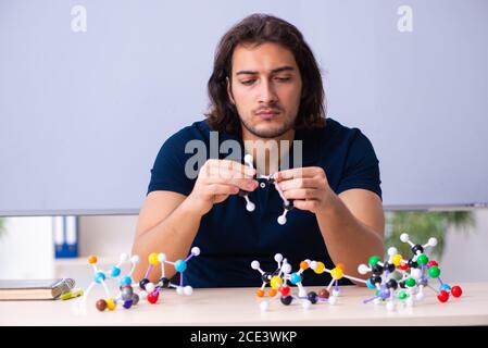 Jeunes scientifiques assis dans la salle de classe Banque D'Images