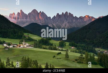 Village de Santa Magdalena et l'église sur la montagne Alpes Dolomites italiennes au lever du soleil Banque D'Images