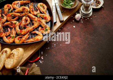 Crevettes grillées dans une poêle en fonte avec citron frais, persil, piment, sauce au vin blanc à l'ail Banque D'Images