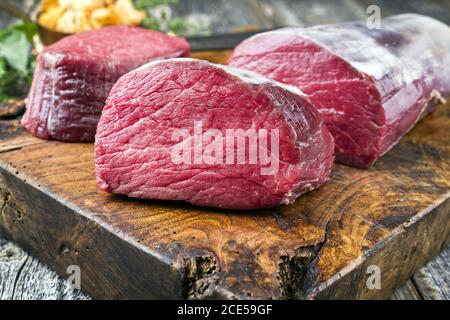 Filet de bœuf vieilli sec, steak naturel comme en gros plan avec des chanterelles sur une planche à découper en bois