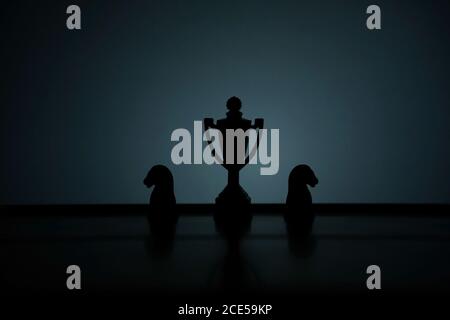 Photo conceptuelle de la stratégie commerciale – Silhouette du stand de trophée table de bureau avec pion d'échecs Banque D'Images