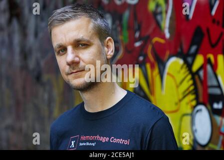 Hambourg, Allemagne. 11 août 2020. Tobias Schlegl, musicien, présentateur, auteur et paramédic d'urgence, porte un T-shirt avec le schéma XABCDE imprimé lors d'une séance photo dans le quartier de Schanzenviertel à l'occasion de la présentation de son nouveau livre 'Schockraum'. (À dpa 'Schockraum' par Tobi Schlegl- roman sur les services de sauvetage au lieu de la thérapie') Credit: Georg Wendt/dpa/Alay Live News Banque D'Images