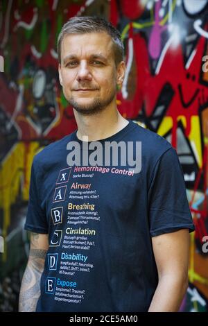 Hambourg, Allemagne. 11 août 2020. Tobias Schlegl, musicien, présentateur, auteur et paramédic d'urgence, porte un T-shirt avec le schéma XABCDE imprimé lors d'une séance photo dans le quartier de Schanzenviertel à l'occasion de la présentation de son nouveau livre 'Schockraum'. (À dpa 'Schockraum' par Tobi Schlegl- roman sur les services de sauvetage au lieu de la thérapie') Credit: Georg Wendt/dpa/Alay Live News Banque D'Images