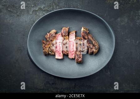 Barbecue traditionnel, hachée de wagyu entrecote, steak de bœuf coupé en tranches vue de dessus sur une plaque en fonte moderne avec copie espace Banque D'Images