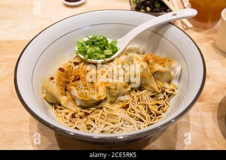 Lanton de porc au Chili Vinaigrette Noodle sec, des oignons de printemps frais sont placés sur la cuillère à louche. Banque D'Images