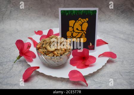 Happy Ganesh chaturthi spécial prasadam Sweet dish festival item Panchakajjjaya offert à Ganapati avec des fleurs d'hibiscus rouges sur fond blanc. INDI Banque D'Images