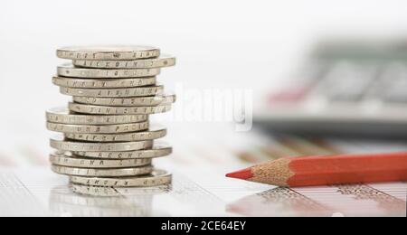 Pièces empilées de monnaie européenne calculatrice à proximité Banque D'Images