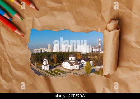 Déchirer un cadre en papier pour révéler le paysage du complexe de l'Église de l'Exaltation de la Sainte-Croix. Minsk, Biélorussie Banque D'Images