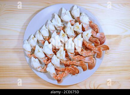 Assiette de pattes de crabe aux fleurs cuites à la vapeur servie sur une table en bois Banque D'Images
