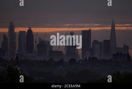 Londres, Royaume-Uni. 31 août 2020. Gratte-ciels sur les gratte-ciel de Londres lors du Bank Holiday Monday vu de Wimbledon comme une aube nuageux brise. Les bureaux de la ville restent calmes alors que les travailleurs financiers continuent de travailler de chez eux pendant la pandémie de Covid-19. Dans l'ombre de premier plan se trouvent les maisons suburbaines de faible hauteur du sud-ouest de Londres. Crédit : Malcolm Park/Alay Live News. Banque D'Images