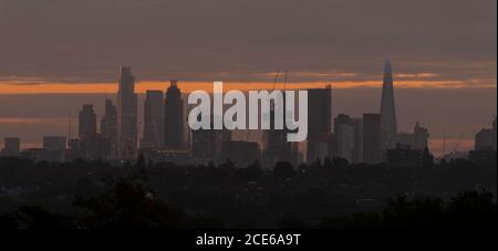 Londres, Royaume-Uni. 31 août 2020. Gratte-ciels sur les gratte-ciel de Londres lors du Bank Holiday Monday vu de Wimbledon comme une aube nuageux brise. Les bureaux de la ville restent calmes alors que les travailleurs financiers continuent de travailler de chez eux pendant la pandémie de Covid-19. Dans l'ombre de premier plan se trouvent les maisons suburbaines de faible hauteur du sud-ouest de Londres. Crédit : Malcolm Park/Alay Live News. Banque D'Images