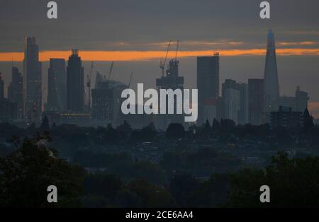 Londres, Royaume-Uni. 31 août 2020. Gratte-ciels sur les gratte-ciel de Londres lors du Bank Holiday Monday vu de Wimbledon comme une aube nuageux brise. Les bureaux de la ville restent calmes alors que les travailleurs financiers continuent de travailler de chez eux pendant la pandémie de Covid-19. Dans l'ombre de premier plan se trouvent les maisons suburbaines de faible hauteur du sud-ouest de Londres. Crédit : Malcolm Park/Alay Live News. Banque D'Images