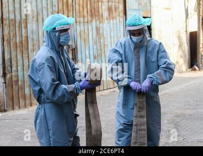 29 août 2020 : Gaza, Palestine. 30 août 2020. Les équipes palestiniennes de défense civile livrent de l'eau potable aux foyers des résidents du camp de réfugiés de Jabalia infectés par le coronavirus, car ils restent en quarantaine et ne peuvent pas récupérer de l'eau potable. Depuis que les premiers cas de coronavirus ont été détectés dans la communauté de Gaza au début de la semaine dernière, le nombre de personnes infectées a régulièrement augmenté à plus de 180 dans l'enclave palestinienne assiégée et densément peuplée. La crise aigue de l'eau dans la bande, où plus de 95 pour cent de l'eau douce ne convient pas à la consommation humaine, met en évidence le déjà grave Banque D'Images