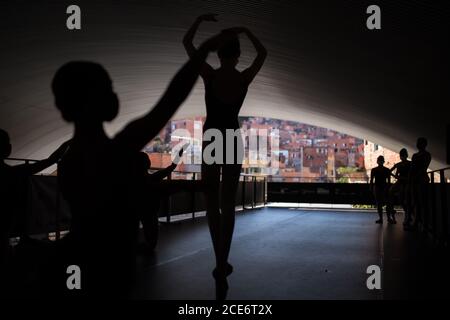 Sao Paulo, Brésil. 28 août 2020. Les filles dansent le ballet devant la Favela Paraisopolis, où vivent plus de 20,000 personnes. Jusqu'à 12 étudiants peuvent participer aux cours de ballet. L'utilisation de masques et une distance maximale de 1.5 mètres sont obligatoires. Les répétitions dans le secteur culturel et créatif de la ville ont été suspendues pendant cinq mois en raison de la pandémie de Corona. Maintenant, les opérations ont repris avec des restrictions. Credit: Andre Lucas/dpa/Alamy Live News Banque D'Images