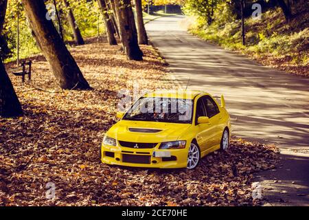 Mitsubishi lancer Evolution 9, tourné dans une route de montagne pleine de feuilles d'automne Banque D'Images