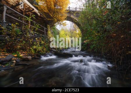 Paysage majestueux de la rivière qui coule à travers la forêt et sous le pont En longue exposition à Grenade Banque D'Images